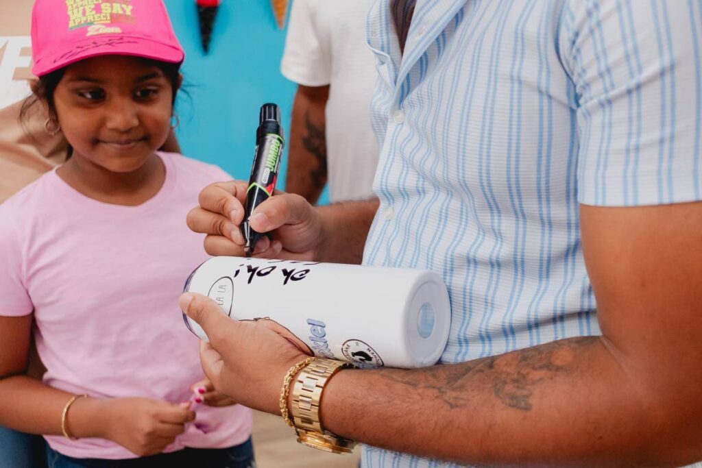 Jamel 'Certified' Sampson signing merch for a fan in Trinidad