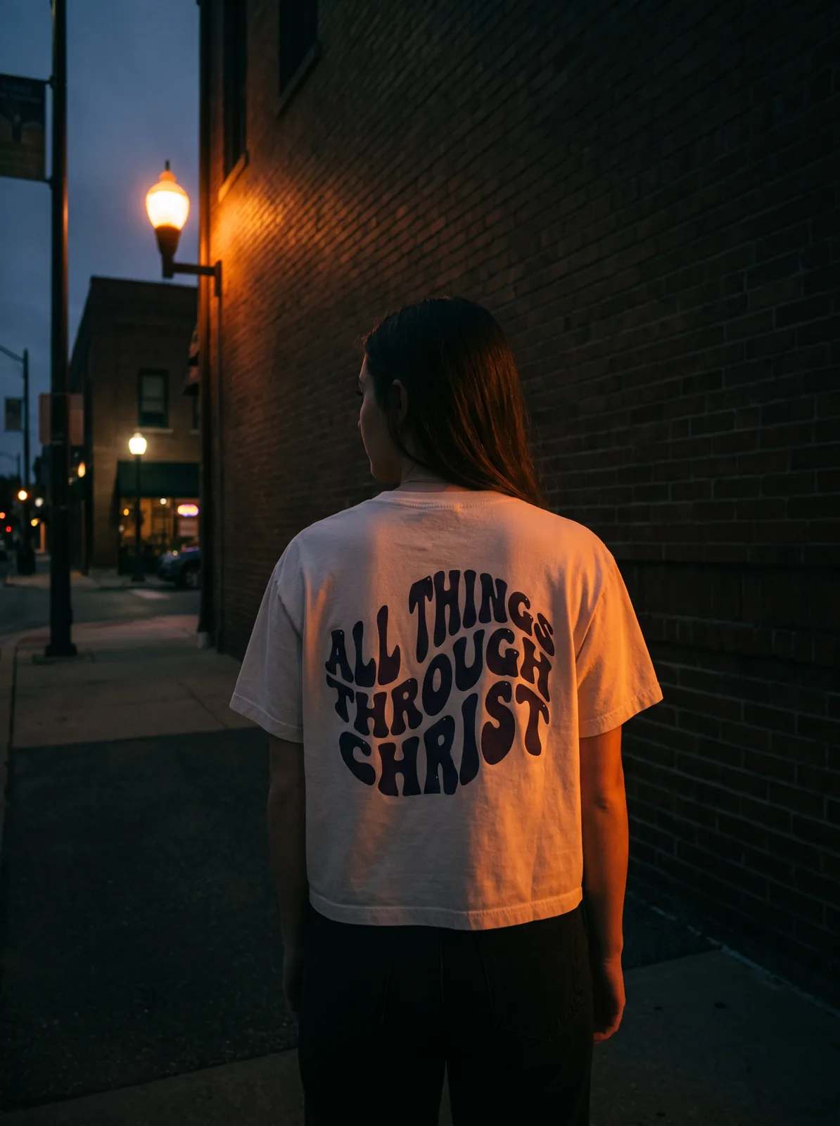 Model wearing the Cream Crop tee on a dusk street corner