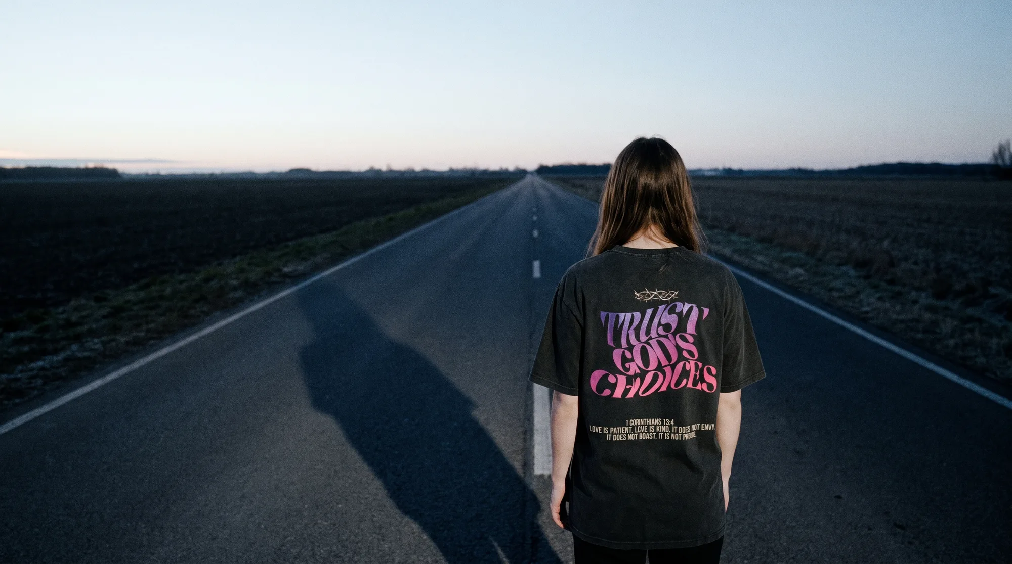 Standing on a long empty road at first light in the Sunset tee